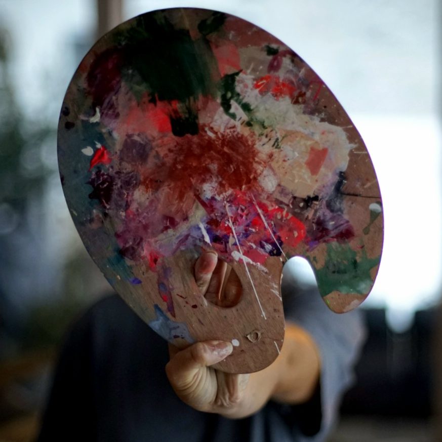 Mulan.Art - Abstrakte Kunst als Therapie Serap Abdul hält eine Farbpalette.